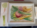 A larger watercolor painting of several vegetables and two smaller paintings of a leek and a carrot