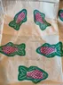 A closer look at an apron with block-printed fish in turquoise and pink ink