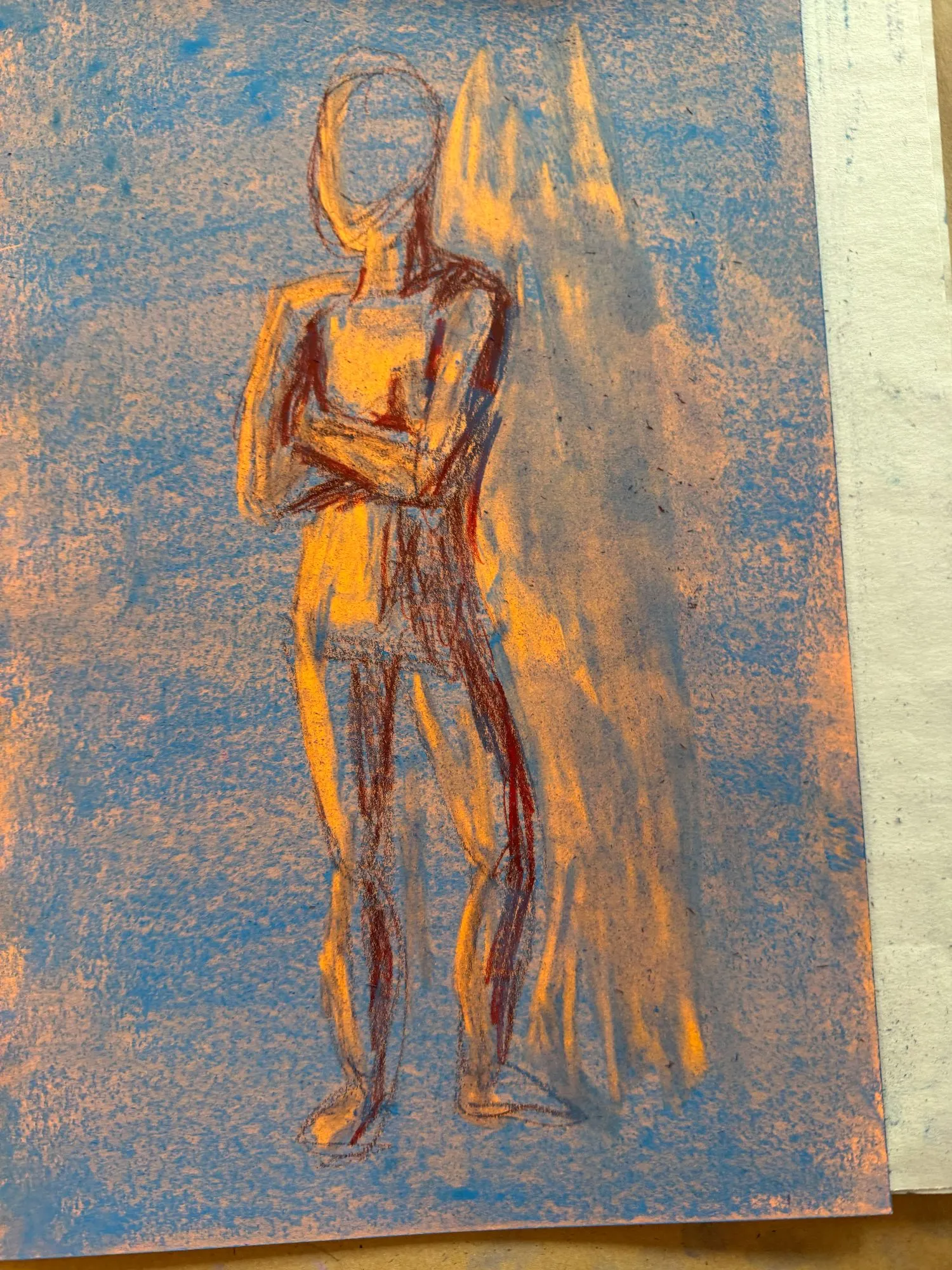 A figure on orange paper covered in blue pastel, the shadows are a dark red and the highlights show the orange paper underneath