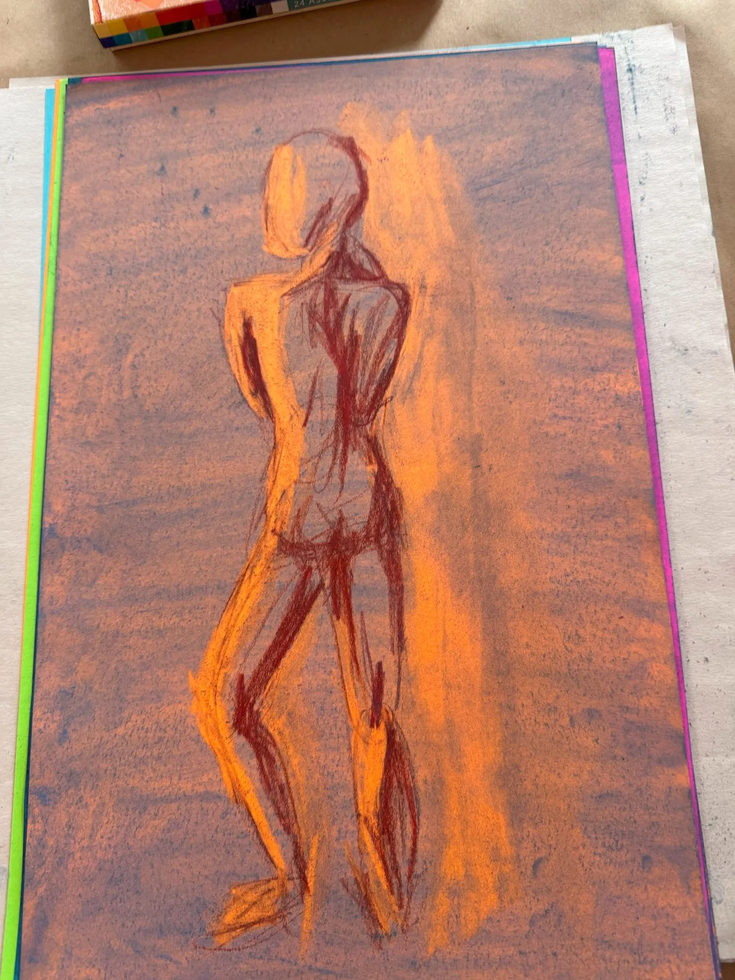 A figure on orange paper covered in blue pastel, the shadows are a dark red and the highlights show the orange paper underneath