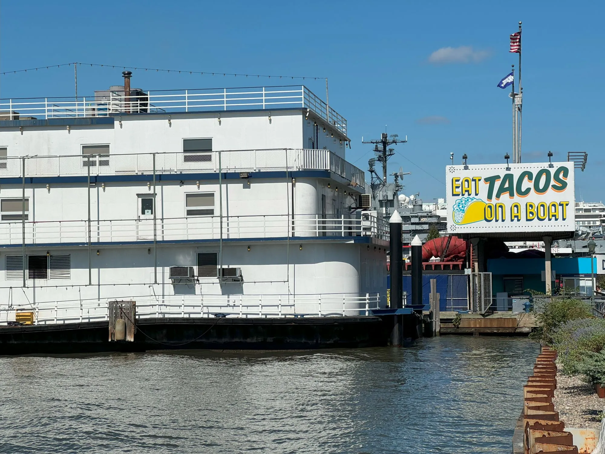A boat with a sign saying 'eat tacos on a boat'