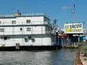 A boat with a sign saying 'eat tacos on a boat'