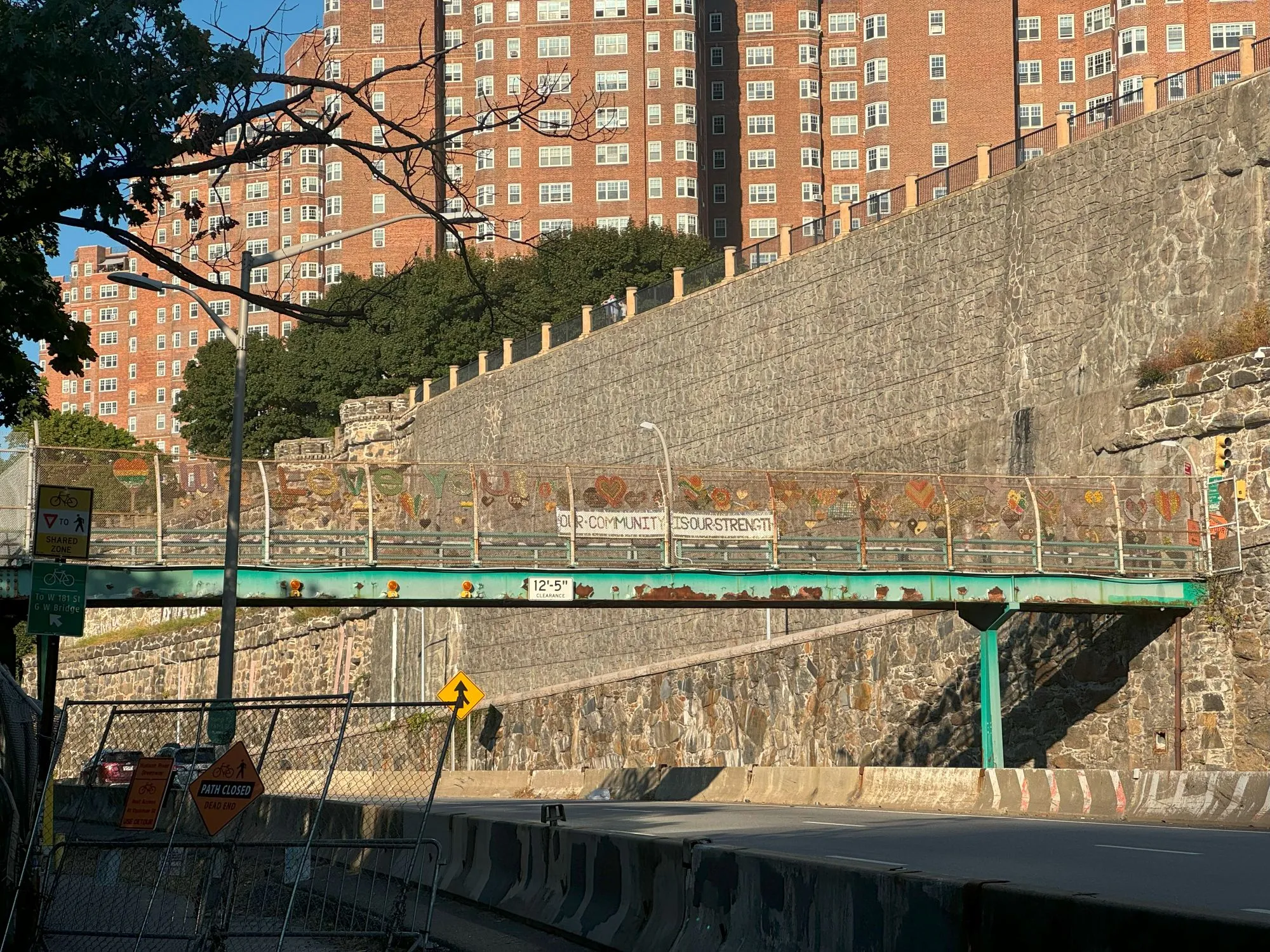 A pedestrian bridge with a sign saying 'Our Community is Our Strength'