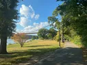 A walking path surrounded by trees with a bridge in the distance