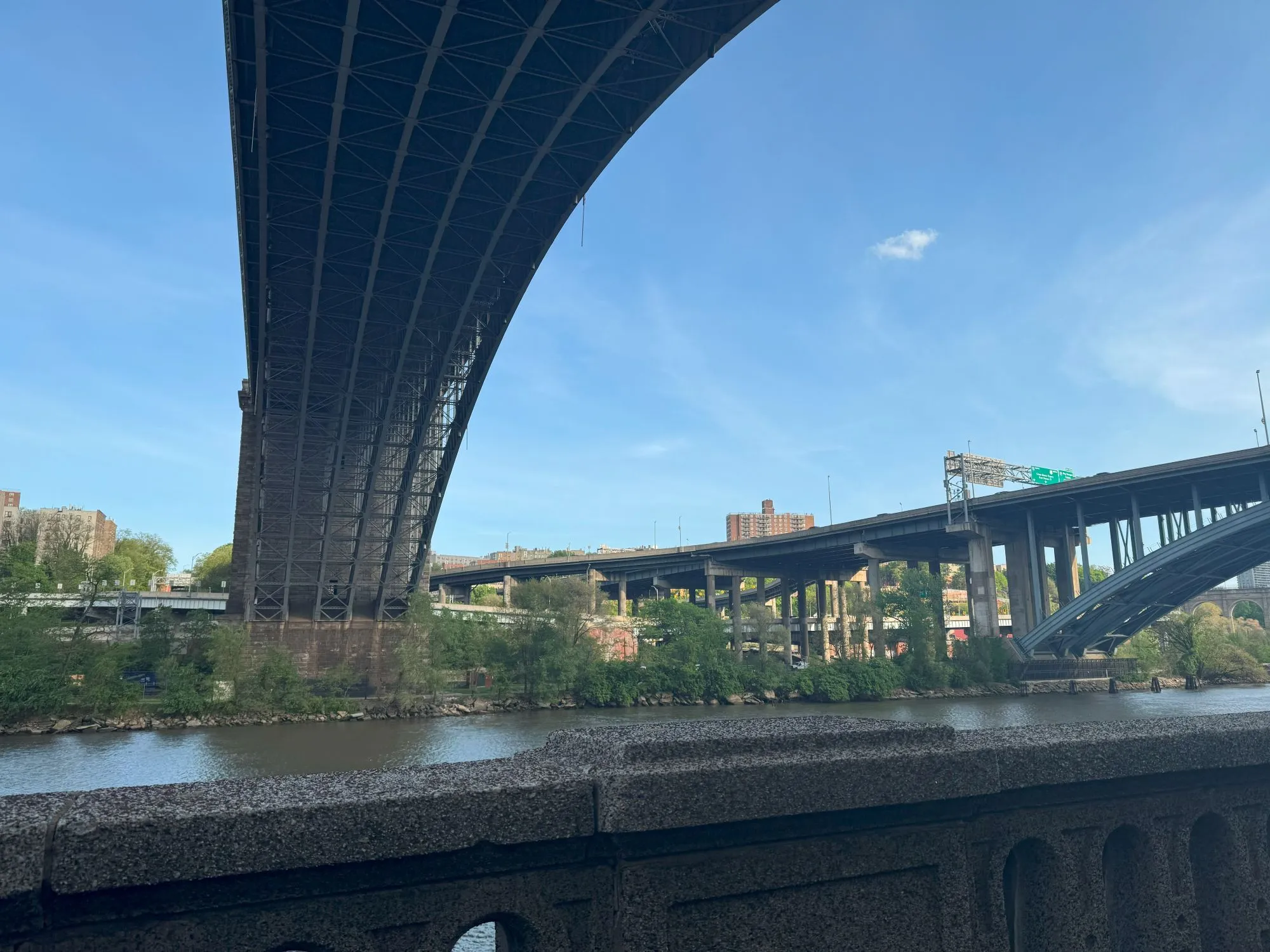 The underside of a bridge with a similar bridge visible further along the path