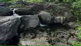 A small pond with water flowing down rock tiers