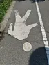 A pedestrian icon on a walking path, with a smiley face painted on the head