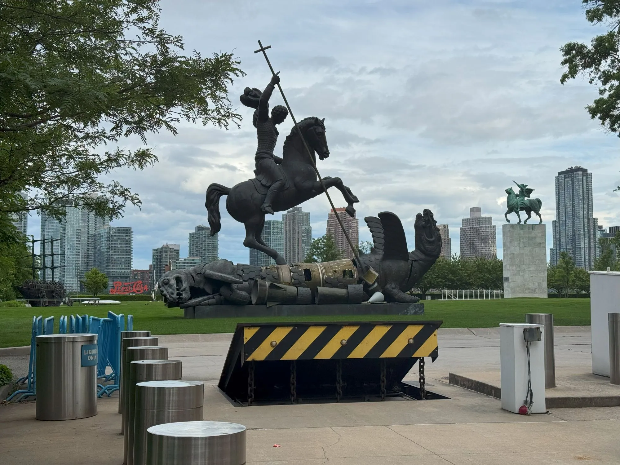 A large statue of a man on a horse fighting winged creatures