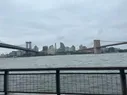 The Manhattan and Brooklyn Bridges visible on either side of the image, both going over the river