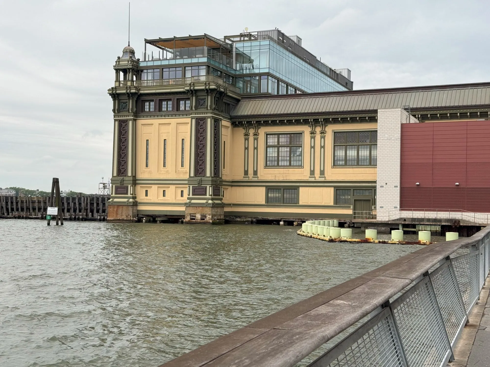 A building jutting into the river with mixed traditional and modern architectural styles