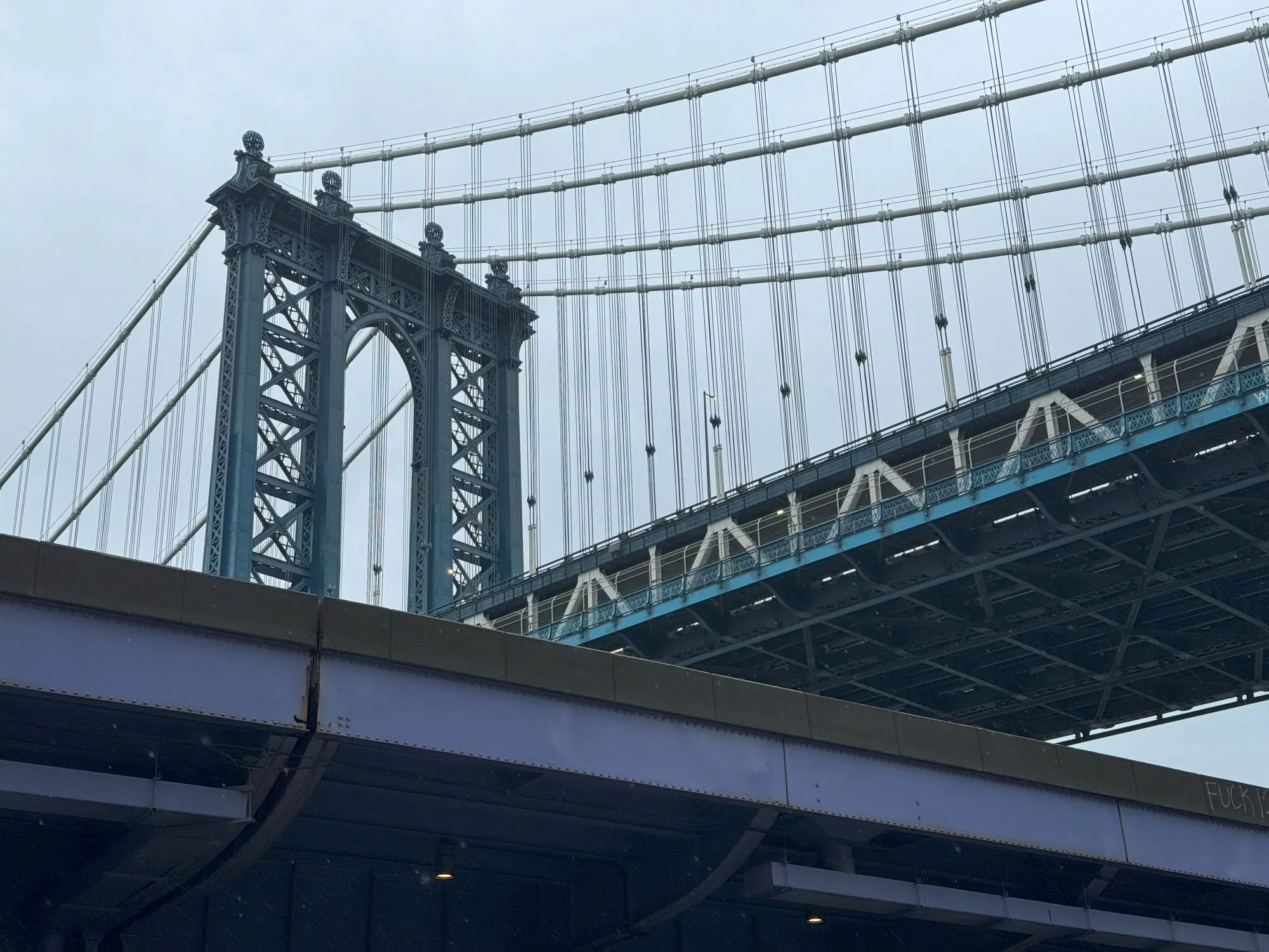 The Manhattan Bridge visible behind a section of elevated highway painted purple