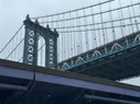 The Manhattan Bridge visible behind a section of elevated highway painted purple
